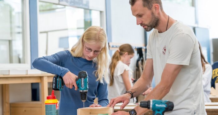 Docent helpt leerlingen met BWI