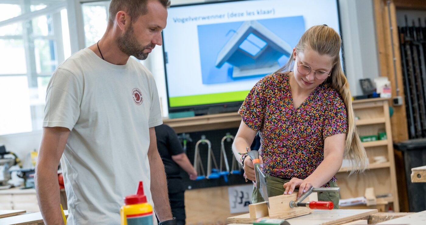 Docent helpt leerlingen bij BWI