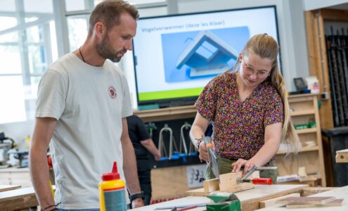 Docent helpt leerlingen bij BWI