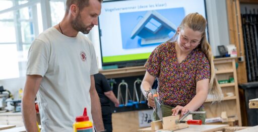 Docent helpt leerlingen bij BWI