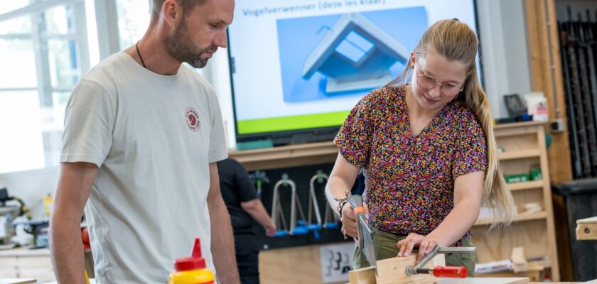 Docent helpt leerlingen bij BWI