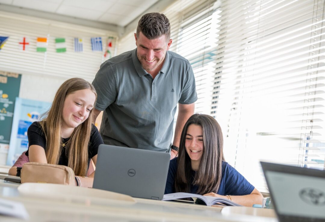 Docent met leerlingen op laptop